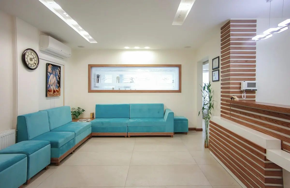 The waiting lounge with teal sofas and warm wood panelling