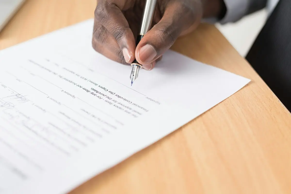 A client signing a document with a fountain pen